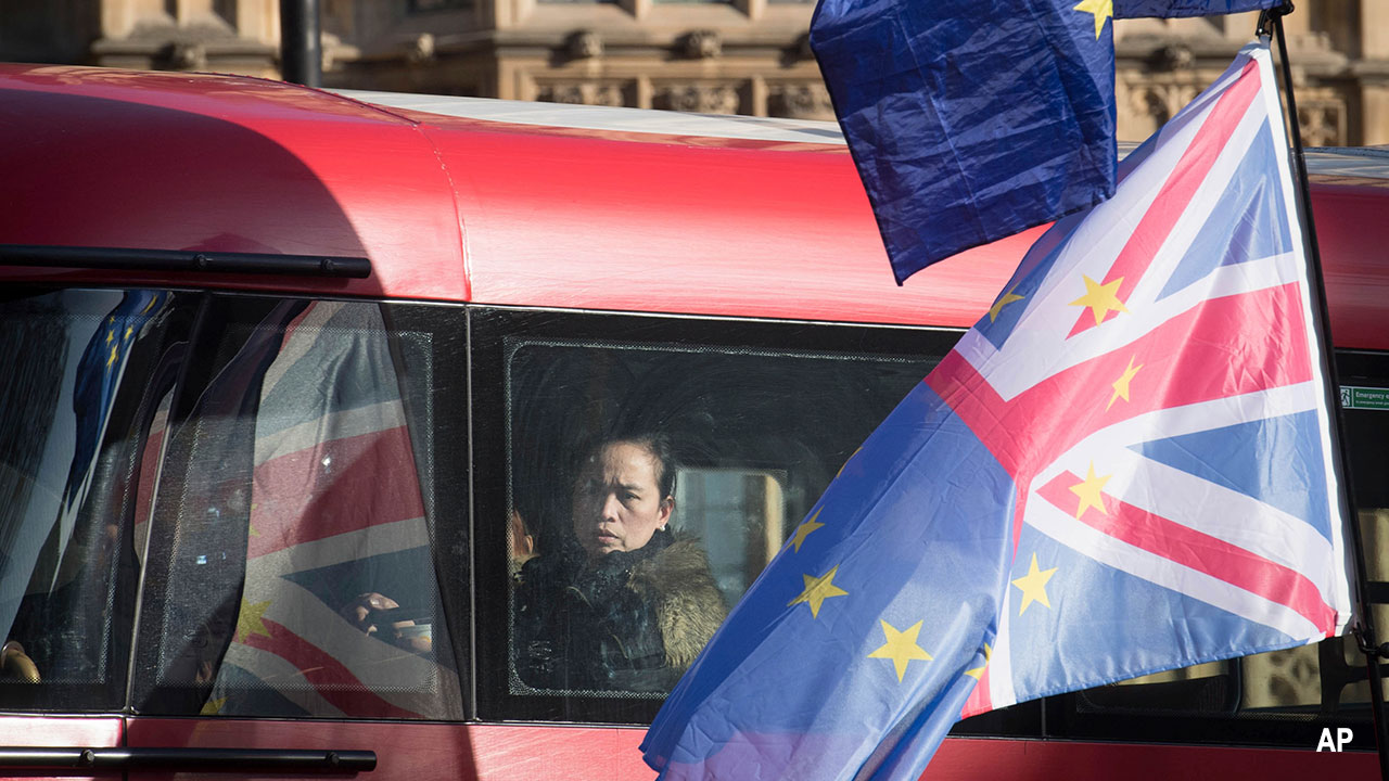 Passengers on a bus pass by an anti-Brexit demonstration in Westminster