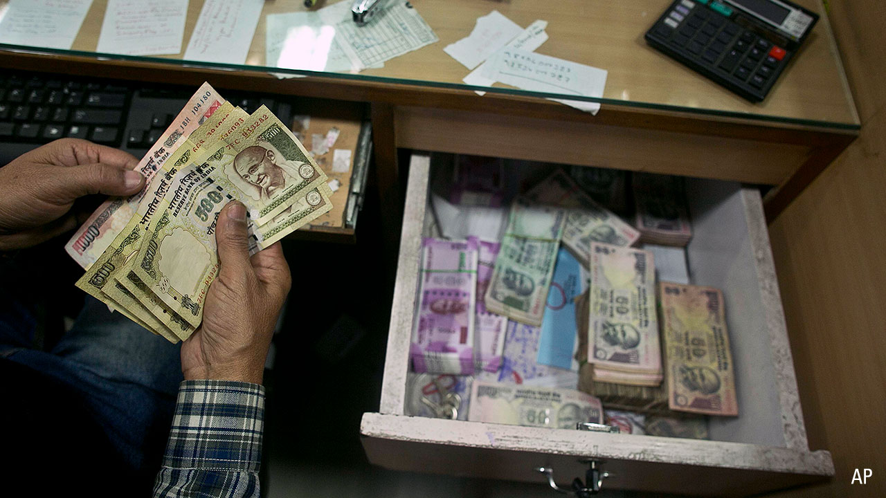 A bank official counts discontinued notes in a bank in Gauhati, India